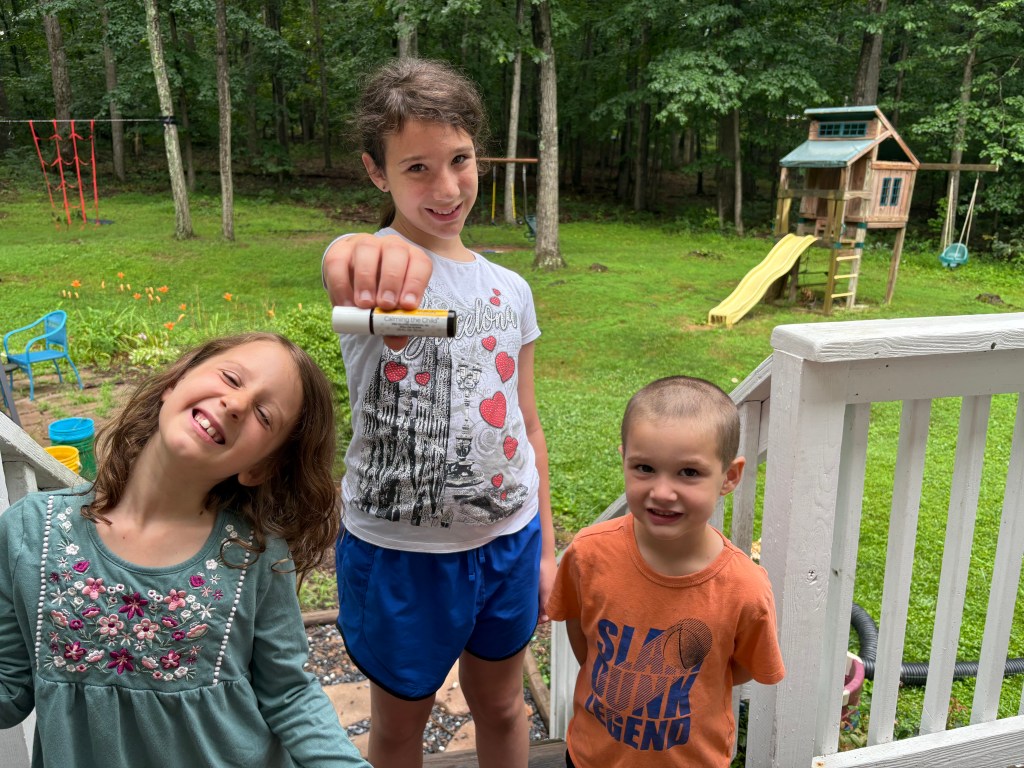 kids hold my favorite essential oil roller outside in nature